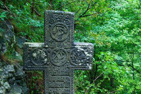 Cross next to the Chapel of the Heart of Queen Mary. Stone Christian cross with religious motifs located near Bran Castle in Romania.の写真素材