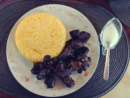 In Romanian, Pastrama de oaie (smoked sheep meat and then barbecue) and in Romanian also, mamaliga (polenta) in a restaurant in Arefu, Romania.の写真素材