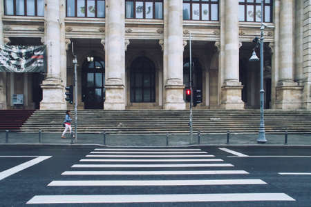 Bucharest, Romania; 07 07 2018: Entrance to the National History Museum on the street "road to victory" (Romanian: Calea Victoriei). Pedestrian crossing and red traffic light for pedestrians.のeditorial素材