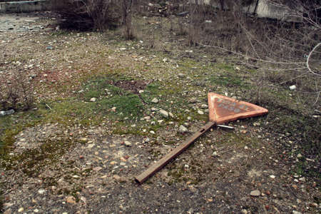 Yield Traffic Sign. Traffic sign thrown and abandoned in the rubble of a dilapidated complex.