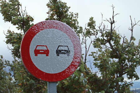 Traffic sign forbidden to overtake. Completely icy traffic sign after a small snowfall.の写真素材