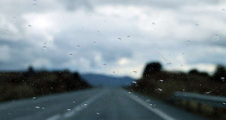 Blurred view through the windshield of a car while driving on a rainy day. Raindrops on the glass...