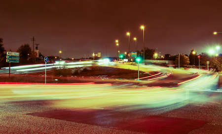 Night traffic in the Montecarmelo neighborhood (Montecarmelo avenue and Tres Olivos bridge) in Madrid. Light trails from car lights, on a rainy night.の写真素材