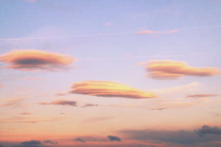 Clouds with warm colors at sunset. Background of clouds in the sky with the last rays of the sun over Madrid, Spain.の写真素材