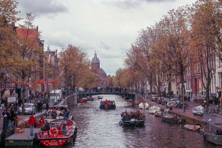 Amsterdam, Holland; 04 30 2016. Canal of Oude Doelenstraat (English: Oude Doelen street) in the queen's day. The typical Amsterdam canal lined with buildings and the narrow streets on its banks.のeditorial素材