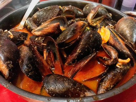 Mussels with spicy sauce in a restaurant in Madrid, Spain. Freshly made casserole with mussels in...