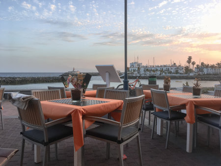 Puerto Mogan, Spain; 04 27 2018. Sunset from Sunset Boulevard restaurant in Puerto MogÃ¡n, Gran Canaria Island. Docks of the marina in the background.のeditorial素材