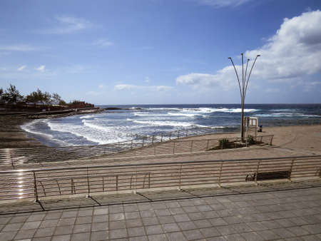 The promenade of El Puertillo, town in the north of Gran Canaria Island, Spain. Coastal waves on a...