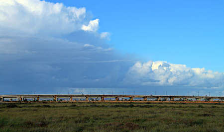 Santa Eulalia bridge and A-497 road bridge in Huelva, Spain. The two bridges over the mouth of the Odiel River with the clouds of a storm approaching from the Atlantic.の写真素材