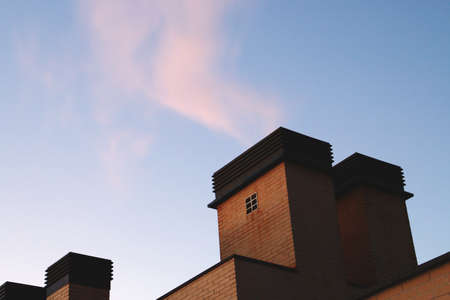Chimney of a modern building at sunrise in Madrid, Spain. Outlet of hot air and water vapor from the...
