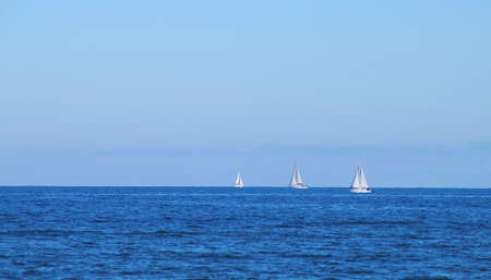 Sailing boats sailing on the horizon at Malvarrosa beach in Valencia, Spain. The Mediterranean Sea...