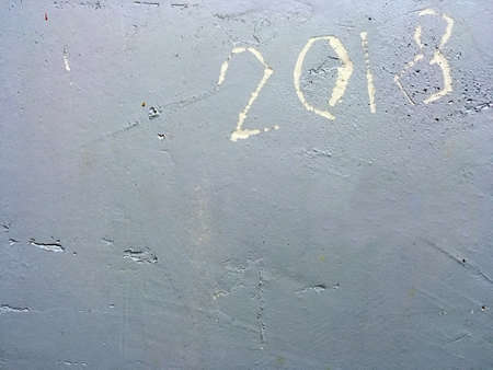 Number 2018 engraved on a wall. Rough gray wall with the number of the year 2018 engraved in the...