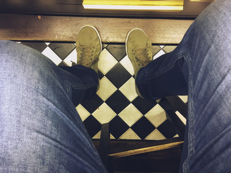 Green sneakers and blue jeans from the photographer's view. Perspective that is observed in the first person when one is seated.の写真素材