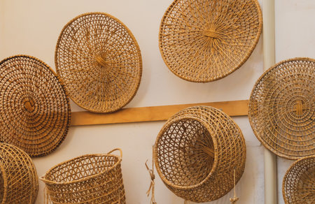 Basketry objects made with natural fibers. Baskets and decorative objects for sale displayed hanging on the outside wall of a shop in Gallipoli, Italy.の写真素材