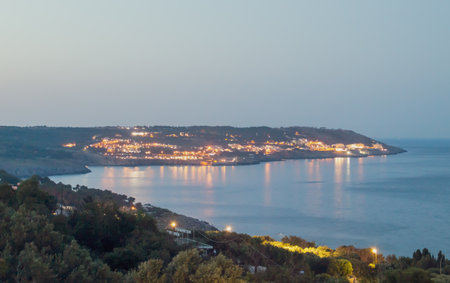 Views of the coast from Armando Perotti square in Castro, Italy. In the distance the city of Santa Cesarea Terme and the calm waters of the Ionian Sea at dusk.の写真素材
