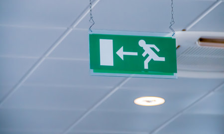Emergency exit sign at Bari-Palese airport, Aeroporto Internazionale di Bari-Karol Wojtyla, Italy. Signaling of the location by means of a sign with a pictogram.の写真素材