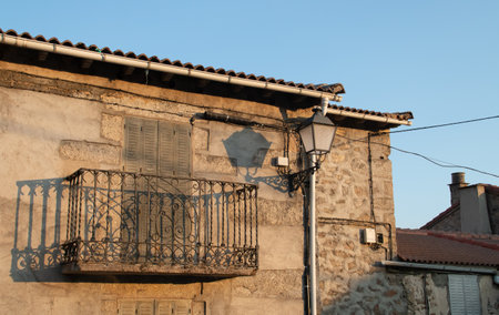 Houses of traditional architecture in Hoyos del Espino, Avila, Spain. Details of an old balcony and lamppost in Pilar square.の写真素材
