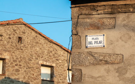 Houses of traditional architecture in Hoyos del Espino, Avila, Spain. Detail of the corner of one of the houses where the plaque with the name of the square is located Pilar squareの写真素材