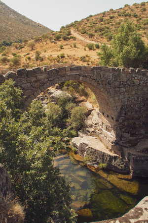 Roman bridge over the Barbellido river in Navacepeda de Tormes in Ãvila, Spain. Stone bridge that crosses over the puddle or pool known as Poza de las Paredes.の写真素材