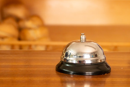 Counter bell in a bakery in SanlÃºcar de Guadiana, Spain. Metal counter bell and in the background some pieces of bread displayed on shelves for sale.の写真素材