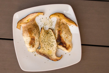 Grilled porcini dish with olive oil. Some delicious boletus cut into slices and drizzled with a little olive oil and seasoned with parsley. Madrid, Spain.の写真素材