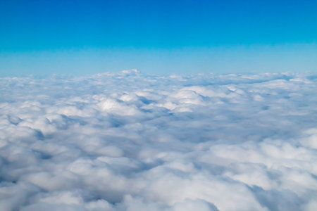 Cloudscape. Blue sky and white clouds. View from airplane windowの写真素材