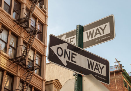 One-way traffic signs on Water Street in Manhattan, New York, USA. In the background, the facade of typical New York buildings with their fire escapes.の写真素材