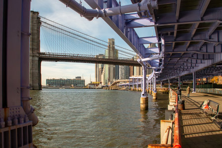 Sunrise on the East River Greenway in New York, USA. People strolling in autumn at sunrise along the East River bank in Lower Manhattan.の写真素材