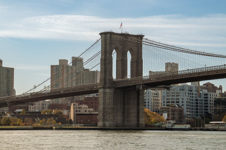Brooklyn Bridge from Manhattan Island. Brooklyn buildings on the banks of the East River at sunrise. November, 2019.の写真素材