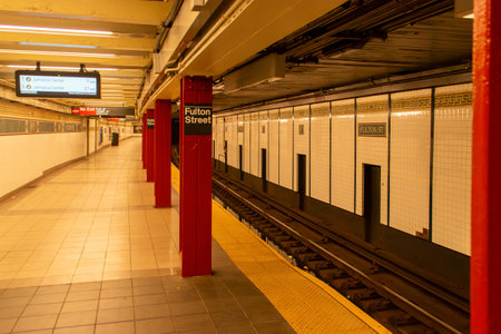 Interior of a subway station platform in New York, USA. Empty platform of the Fulton St. subway station with a soft warm lighting.の写真素材