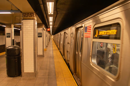 Interior of a subway station platform in New York, USA. Subway train running in Canal St. station with soft warm lighting. November 2019.の写真素材