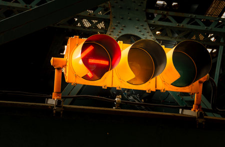 Red traffic light for vehicles on a street in New York, USA. Traffic light with a red arrow indicating the obligation to stop if turning left in the Harlem neighborhood.の写真素材