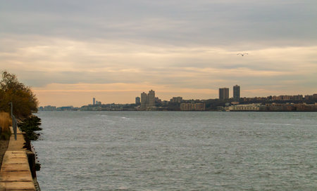 Hudson River at sunset on a cloudy autumn day from New York. Views of New Jersey from the Hudson River Greenway in Manhattan.の写真素材