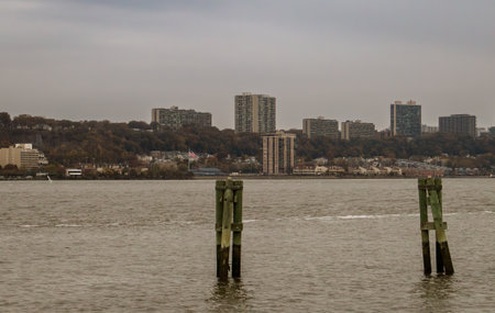 Wooden pilings on the Hudson River with New Jersey in the background. Hudson River at sunset on a cloudy autumn day from New York.の写真素材