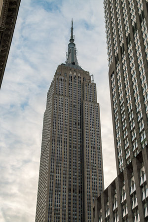 The Empire State Building skyscraper on 5th Avenue, NYC, USA. New York City skyline with a large skyscraper in the center of Manhattan seen from a low angle.の写真素材