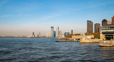 Wooden pier with pilings south of Manhattan's financial district, New York City, USA. In the background, Panoramic view of New Jersey skyscrapers across the waters of the Upper Bayの写真素材