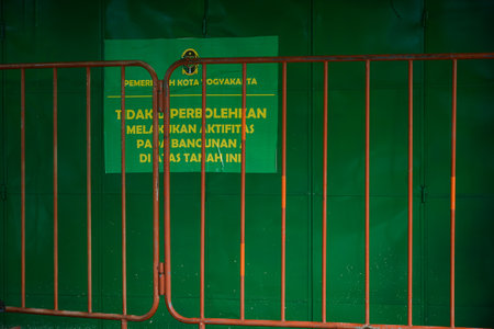 Malioboro, Yogyakarta, Indonesia - Januari 07, 2022: orange fence in front of a closed green door with a prohibited to use sign.
the Yogyakarta city government sealed the shops on "Perwakilan" Street because they were deemed not to have a permit.のeditorial素材