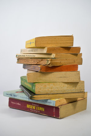 Yogyakarta, Indonesia - January 06, 2023: Pile of old books on a white background.のeditorial素材