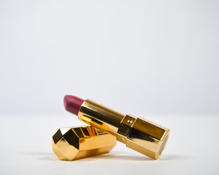 Lipstick with golden colored tube over white background.の写真素材