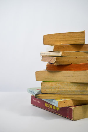 Yogyakarta, Indonesia - January 06, 2023: Pile of old books on a white background.のeditorial素材