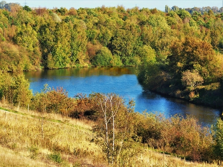Rive Aire lined by autumn trees seen from Fairburn Ings nature reserve, Yorkshire, Englandの写真素材
