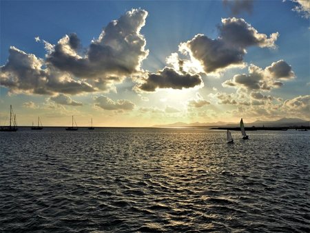 Sailing boats below a dramatic sunset sky seen from Arrecife, Lanzarote in the Canary Islandsの写真素材