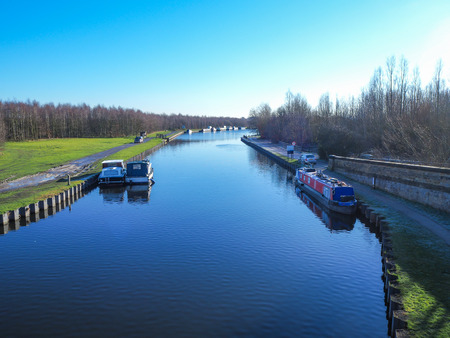 Section of the Aire and Calder Navigation Canal in West Yorkshire, England, with boats on a clear...