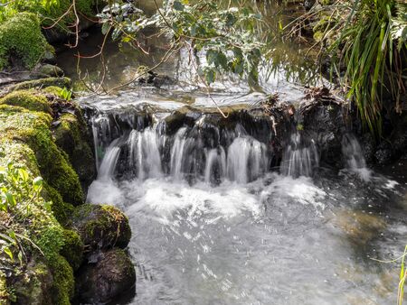 Small waterfall in a stream running through Peasholm Park, Scarborough, North Yorkshire, Englandの写真素材