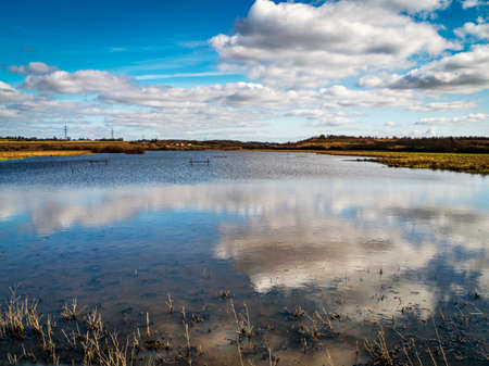 Clouds reflected in wetlands at Fairburn Ings, West Yorkshire, Englandの写真素材