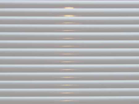Cream Venetian blinds with light closeup abstractの写真素材
