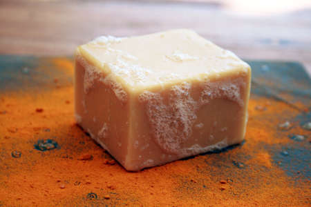 Organic, handcrafted turmeric soap bar with bubbles and turmeric powder.の写真素材