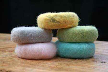 Wool covered organic soap stacked with a black background.の写真素材