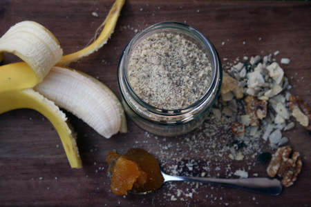 Healthy smoothie ingredients, banana, honey and crushed nuts and seeds.の写真素材