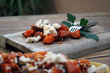 Roasted sweet potato salad with feta and parsley garnish.の写真素材